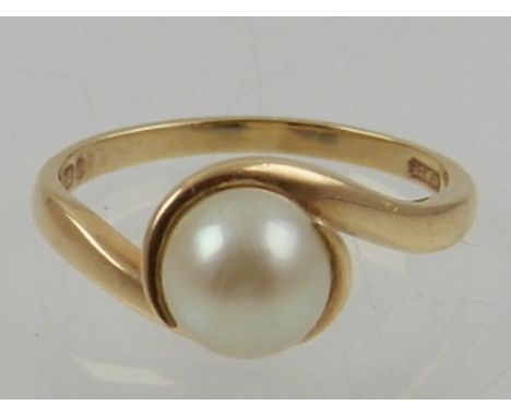 A 9 carat yellow gold and pearl crossover style ring.