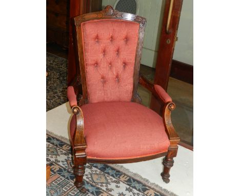 A Victorian walnut button upholstered armchair, having carved show-wood back above open arms and over-stuffed seat, raised on