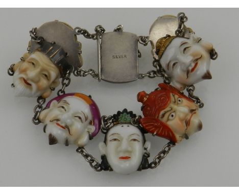 An early 20th century Japanese white metal and ceramic charm bracelet, the charms fashioned as Japanese theatre masks, stampe