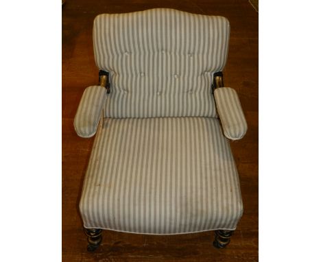 A Victorian button upholstered ebonised and giltwood arm chair, coved in cream and grey striped fabric, the open arms incorpo