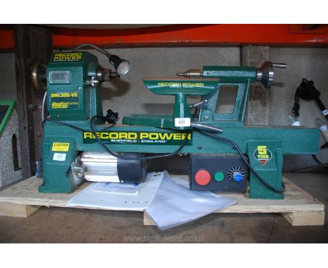 A Record power DNL305 VS Wood turning Lathe with variable controller and work light and a large box of various chucks, jaws, 