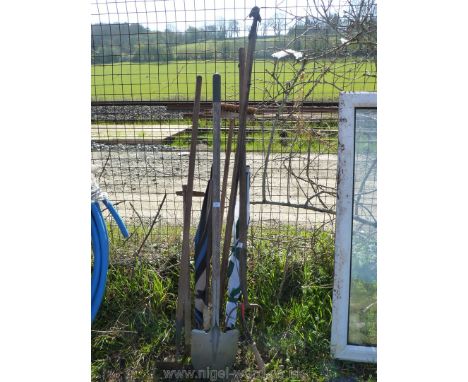 A bundle of garden tools including. branch lopper, spade, brooms and umbrellas etc.