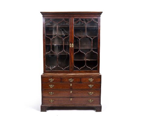 A George III mahogany library bookcase, with twin astral glazed door above a caddy top with a brushing slide, three short and