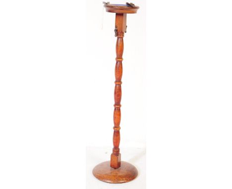 A vintage 20th century mahogany pedestal free standing floor standing ashtray. The ashtray having metals rests over a blue an