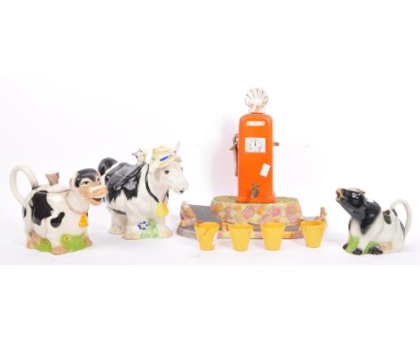 A collection of 20th Century vintage ceramic pottery novelty drinking items to include shell petrol pump drink dispenser with