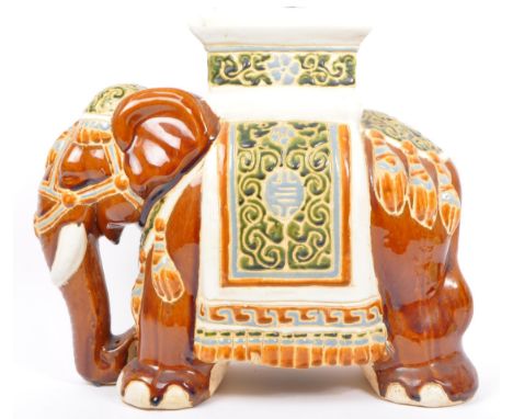 A 20th century ceramic jardini&egrave;re plant stand modelled in the form of a brown elephant with polychrome glazed Nettipat