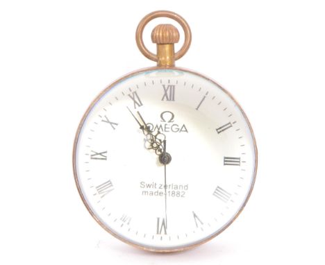 A vintage Omega style desktop glass orb clock having a white enamelled face with roman numerals to the chapter ring and pierc