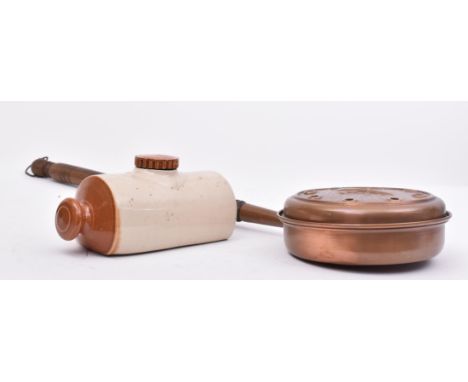 A nineteenth century French copper bed warming pan with fleur de lis central motif, along with an unmarked ceramic hot water 