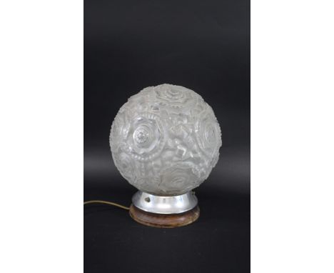 ART DECO GLASS LAMP with a large circular frosted glass shade with star burst design, with a metal base and mounted on a wood