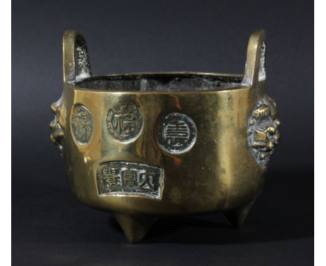 CHINESE BRASS TRIPOD CENSER, stamped with various roundels and panels between two lion heads and hoop handles, seal mark, dia