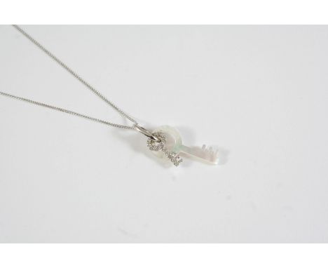 A DIAMOND AND MOTHER OF PEARL KEY PENDANT set with a mother of pearl key and a diamond set key on an 18ct white gold chain