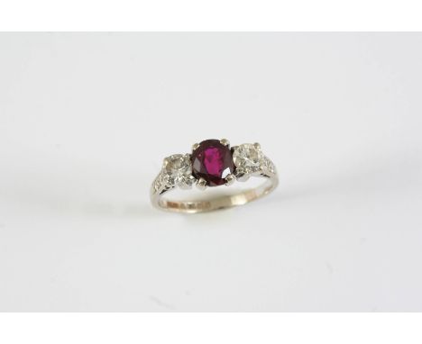 A RUBY AND DIAMOND THREE STONE RING the oval-shaped ruby is set with two round brilliant-cut diamonds, with two single-cut di