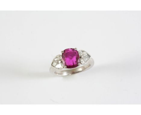 A RUBY AND DIAMOND RING the cushion-shaped ruby weighs 2.45 carats and is set with two pear-shaped and a square-cut diamond t