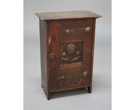 ARTS &amp; CRAFTS WALL CABINET - SHAPLAND &amp; PETTER an oak cupboard with a central copper panel with floral design, and wi