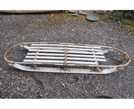 A MID CENTURY WOODEN SLED, with rope bindings, a bentwood top rail and curved skids