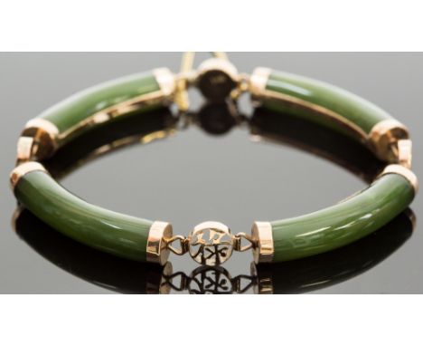 A 14k gold and jade bangle, with four cylindrical links, divided with character mark spacers, 18.5g