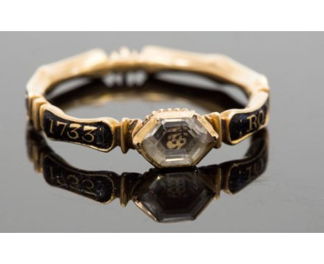 An 18th Century mourning ring, a picture of a skull beneath an octagonal faceted crystal, the band decorated with black ename