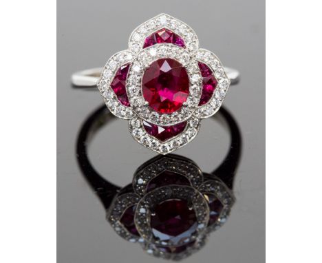 A platinum, ruby and diamond ring, set with cushion-cut and calibre-cut rubies approx 1.43ct total, surrounded by round brill