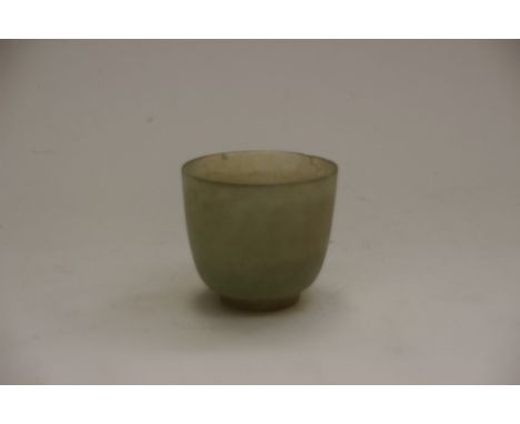 A carved jade cup, of plain round funnel form with cylindrical foot, 5cm high