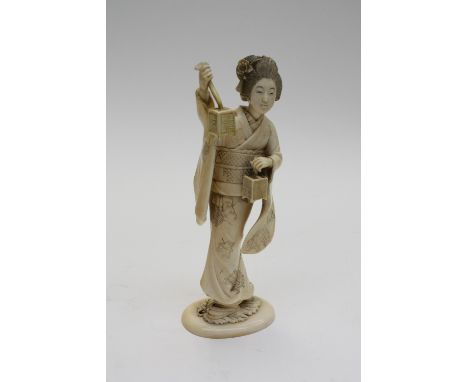 A 19th century carved ivory figure of a Geisha holding a lantern and basket, 17.5cm high