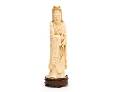 A 19th century Chinese carved ivory figure of a woman with rosary, holding a pearl, on a hardwood base, 24.5cm high