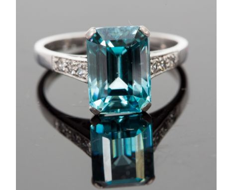 An 18ct white gold, zircon and diamond ring, set with a step-cut blue zircon approx 5.24cts, flanked by six diamonds to shoul