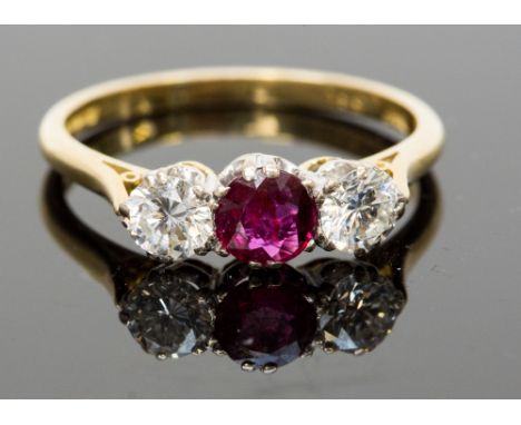 An 18ct gold, ruby and diamond three-stone ring, the central ruby approx 0.57ct, flanked by two round brilliant cut diamonds 