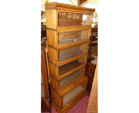A 1920s/30s Globe Wernicke style oak and metal bound six tier stacking book case, the lower protruding tier with further sing