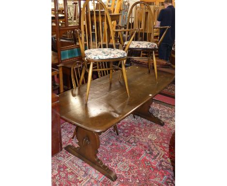 An Ercol dark elm dining suite, comprising; round cornered trestle end dining table, length 180cm, and a matching set of six 