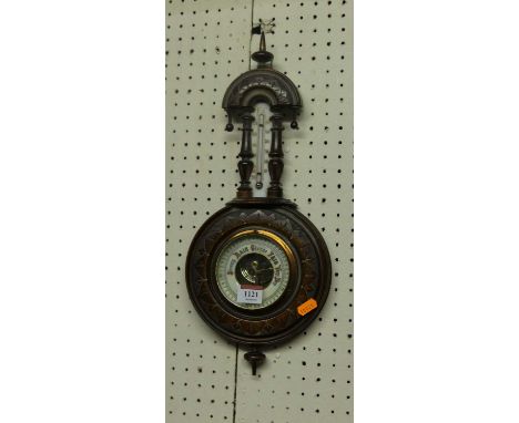 A small early 20th cenutry relief carved walnut aneroid two-dial barometer