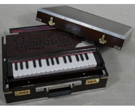 A modern portable harmonium from the Calcutta Harmonium Shop in metal bound hardwood carrying case. H.28cm 