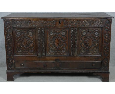 A 17th century carved oak coffer fitted with base drawers on shaped bracket feet. H.84 W.138 D.52cm 