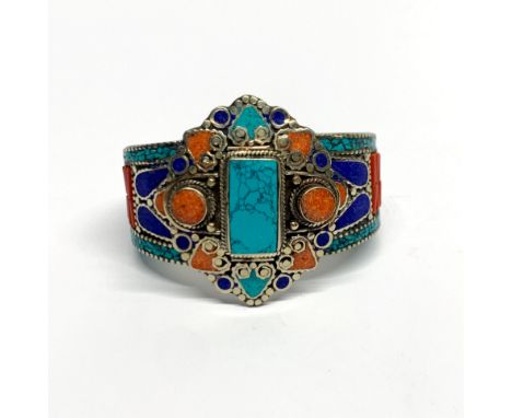 A Tibetan stone set tribal white metal bangle, top setting W. 5.5cm.