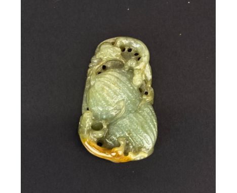A Chinese carved celadon and russet jade amulet of two young dragons on a bitter gourd, H. 4.5cm.