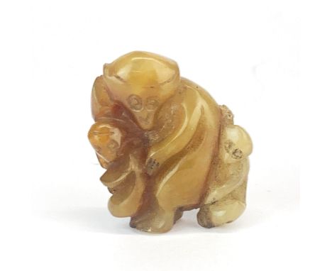A Chinese carved russet jade amulet of a monkey mother with two young, H. 4cm.