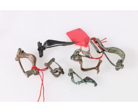 An antique Roman Aucissa fibula with reeded ribbon bow, 7.5 cm and a group of six small fibulae, 2.5-6 cm (7). 