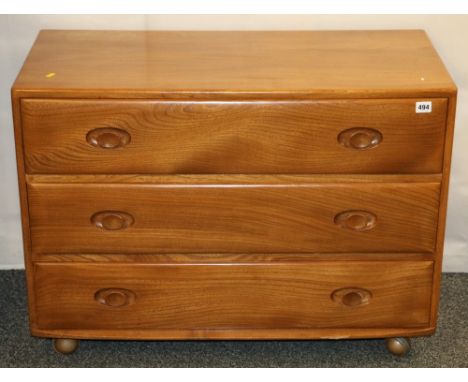 Ercol oak bedroom chest of three drawers raised on casters, 92cm wide Chip to the front edge at the base, some light scratchi