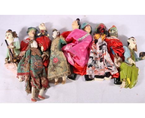 Chinese early 20th century doll with silk robe and wooden body, another with dragon robe, eight further dolls some with paint