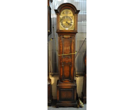 Early 20th Century oak presentation longcase clock in Jacobean style with arched brass face, having Roman silvered chapter ri