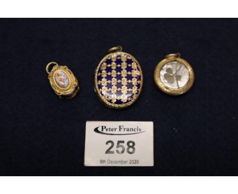 A Yellow metal and enamel viniagrette, a yellow metal and blue enamel locket and a yellow metal photograph locket. (B.P. 21% 