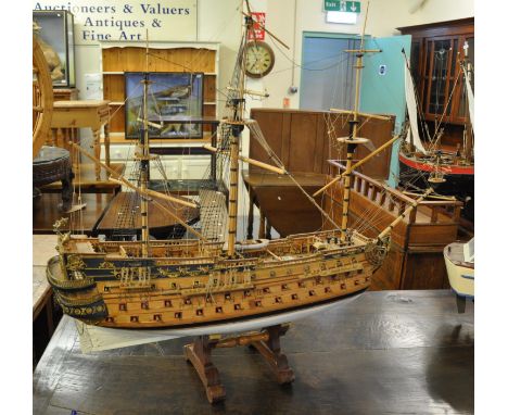 A kit built wooden scale model of a 17th Century three decker three masted man o'war. 1M long approx, on wooden display stand