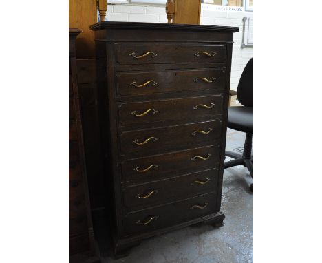 Early 20th century oak narrow straight front chest of seven drawers on projecting base and bracket feet.(B.P. 21% + VAT) 