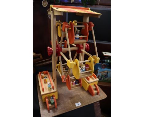 Wooden toy model of a ferris wheel with painted and detailed passengers on rectangular base. 62.5cm high approx. Made and exh