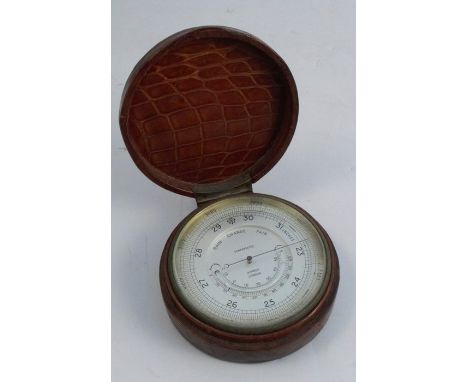 An Asprey London cased compensated barometer, the textured leather circular case, with hinged lid, revealing a barometer and 