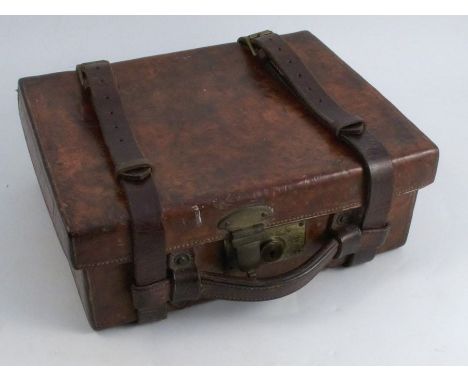 An Army and Navy leather covered cartridge magazine, the case opening to reveal four compartments with leather straps, the ou