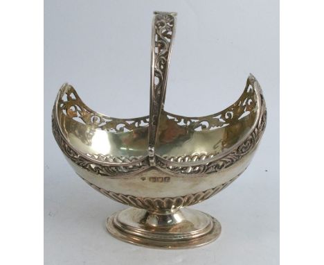 A silver oval basket, with swing handle, having pierced decoration and a gadrooned lower body, raised on a stepped oval base,