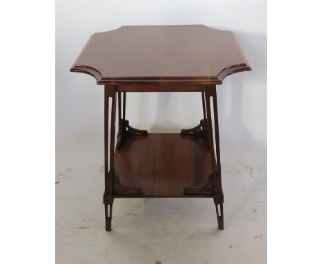 An Art Nouveau walnut occasional table, fitted with an under-shelf, having shaped, pierced brackets standing on cut-out squar