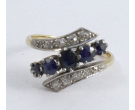 A sapphire and diamond cross over ring, stamped '18ct Plat' with a central line of five graduated sapphires, between shoulder