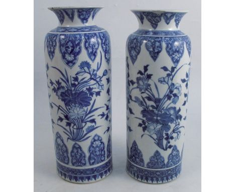 A pair of Chinese Kangxi style vases, decorated in blue and white with flowers, artemisia leaf mark within two circles to bas