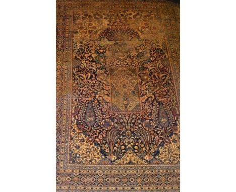 Persian pattern small carpet, fawn ground with a central floral medallion, trellis field within spandrels, broad border, appr